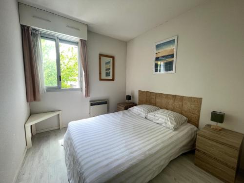 une chambre avec un grand lit et une fenêtre dans l'établissement T3 spacieux à l'Aiguillon, pour 6 pers. avec terrasse, proche plages et commerces - FR-1-420-150, à Arcachon