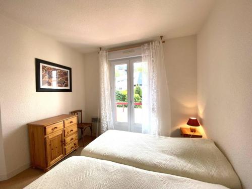 - une chambre avec un lit, une fenêtre et une commode dans l'établissement Appartement à 200m de la plage avec 2 chambres et garage à Perros-Guirec - FR-1-368-422, à Perros-Guirec