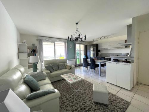 un salon et une cuisine avec un canapé et une table dans l'établissement Charmant T3 au Centre d'Arcachon - 70 m², Terrasse, Proche Plages et Commerces, WIFI - FR-1-420-151, à Arcachon