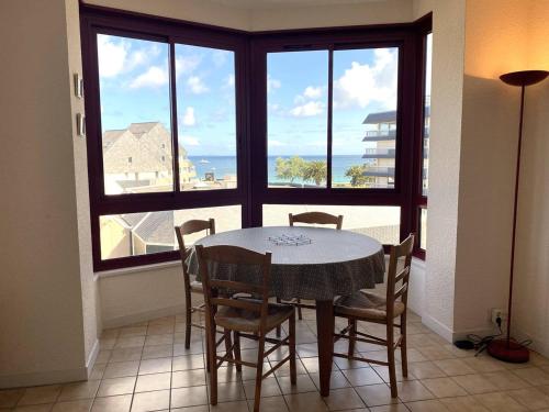 une salle à manger avec une table et des chaises et une fenêtre dans l'établissement Appartement à 200m de la plage avec 2 chambres et garage à Perros-Guirec - FR-1-368-422, à Perros-Guirec