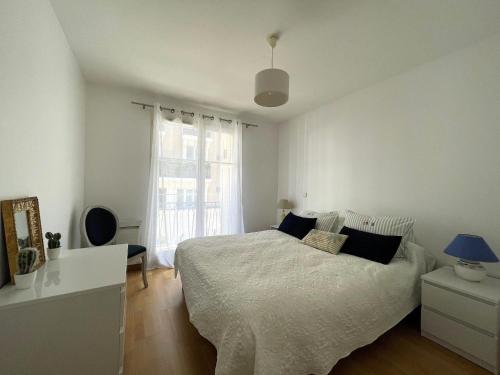 une chambre blanche avec un lit et une fenêtre dans l'établissement Charmant T3 au Centre d'Arcachon - 70 m², Terrasse, Proche Plages et Commerces, WIFI - FR-1-420-151, à Arcachon
