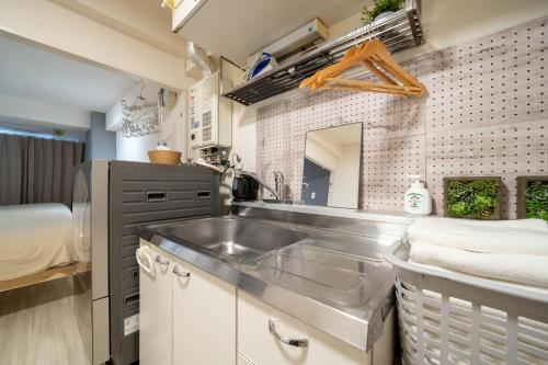 una cucina con lavandino in acciaio inossidabile e un letto di South 1014 a Sapporo