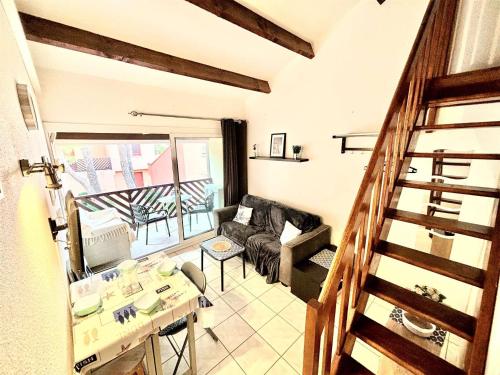 un salon avec un canapé et une table dans l'établissement Appartement Studio Climatisé avec Mezzanine et Terrasse à 400m de la Plage - 4 Couchages - FR-1-229C-97, à Port-la-Nouvelle