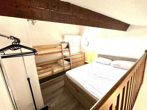 une petite chambre avec un lit et un berceau dans l'établissement Appartement Studio Climatisé avec Mezzanine et Terrasse à 400m de la Plage - 4 Couchages - FR-1-229C-97, à Port-la-Nouvelle