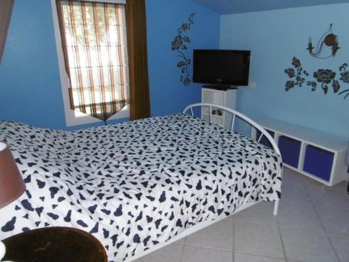 une chambre avec un lit avec une couette noire et blanche dans l'établissement Maison avec Piscine Chauffée, Proche Plage, 3 Chambres, Jardin Clôturé, Wifi Inclus à St Hilaire de Riez - FR-1-652-44, à Saint-Hilaire-de-Riez