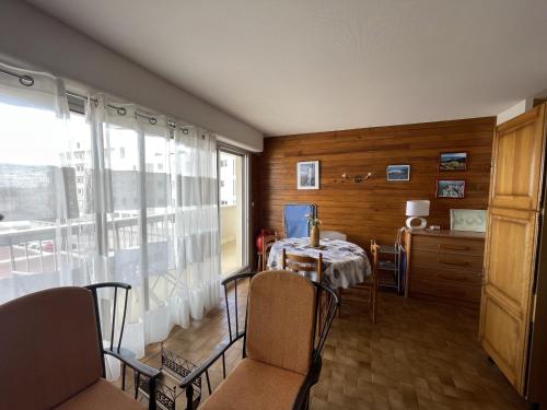 une salle à manger avec une table et des chaises et une fenêtre dans l'établissement Appartement T2 lumineux 51m², centre-ville, près des plages, parking, terrasse - FR-1-71-105, à Royan