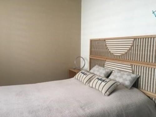 une chambre avec un lit avec une tête de lit en bois dans l'établissement Studio cosy près de la plage des Présidents, tout équipé, loggia, quartier recherché, vélos gratuits - FR-1-325-131, à Les Sables-dʼOlonne