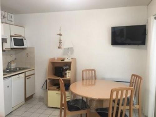 une cuisine avec une table et des chaises dans une pièce dans l'établissement Studio cosy près de la plage des Présidents, tout équipé, loggia, quartier recherché, vélos gratuits - FR-1-325-131, à Les Sables-dʼOlonne