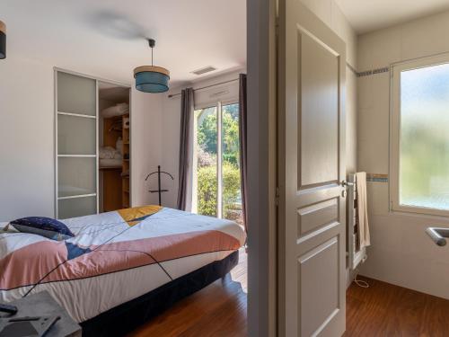 une chambre avec un lit et une porte coulissante en verre dans l'établissement Villa familiale avec piscine chauffée, clim, 4 chambres, proche golf et plages - FR-1-319-565, à Biscarrosse