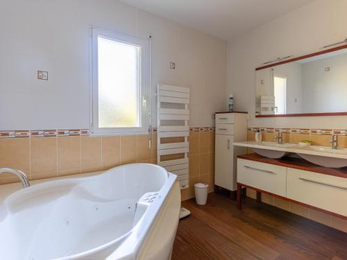 une grande salle de bain avec une baignoire et un lavabo dans l'établissement Villa familiale avec piscine chauffée, clim, 4 chambres, proche golf et plages - FR-1-319-565, à Biscarrosse