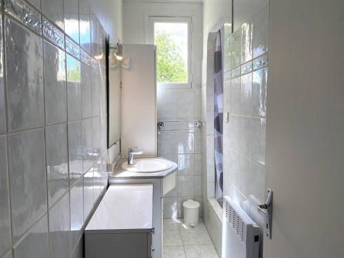 une salle de bain blanche avec un lavabo et des toilettes dans l'établissement Charmante maison rénovée à Trébeurden avec jardin clos, terrasse et parking, à 1km de la mer - FR-1-368-423, à Trébeurden