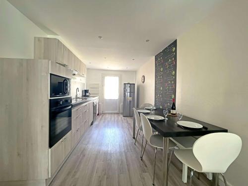 une cuisine avec une table et des chaises dans une pièce dans l'établissement Maison de ville à Berck Plage, terrasse et garage, proche plage et commerces - FR-1-646-65, à Berck-sur-Mer