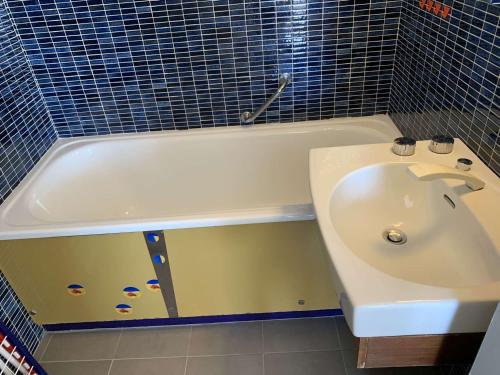 une salle de bain avec un lavabo et une baignoire dans l'établissement Port Camargue : Charmant T3 refait, 100m plage, piscine privée, parking, pour 4 pers. - FR-1-731-70, au Grau-du-Roi