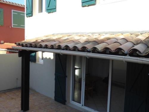un toit de maison avec une porte et un bâtiment dans l'établissement Villa climatisée refaite à neuf au calme avec piscine, terrasse et parking, proche plage et port - FR-1-723-159, au Cap d'Agde