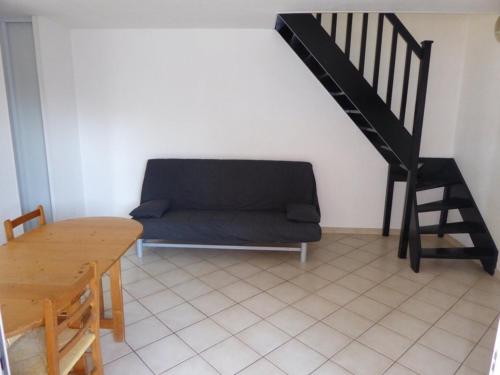 un salon avec un canapé et un escalier dans l'établissement Villa climatisée refaite à neuf au calme avec piscine, terrasse et parking, proche plage et port - FR-1-723-159, au Cap d'Agde