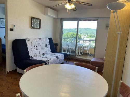 un salon avec une table et un canapé dans l'établissement Appartement 2 pièces climatisé proche plage à Bormes-les-Mimosas - FR-1-251-834, à Bormes-les-Mimosas