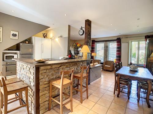 une cuisine et un salon avec une table et des chaises dans l'établissement Charmante maison F4 avec terrasse proche Thermes et centre, animaux acceptés - FR-1-451-210, à Lamalou-les-Bains