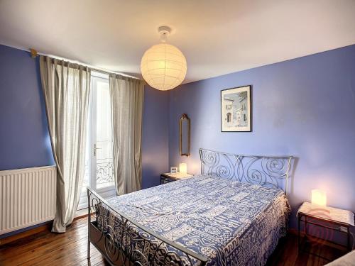 une chambre avec un lit et un mur bleu dans l'établissement Charmante maison F4 avec terrasse proche Thermes et centre, animaux acceptés - FR-1-451-210, à Lamalou-les-Bains