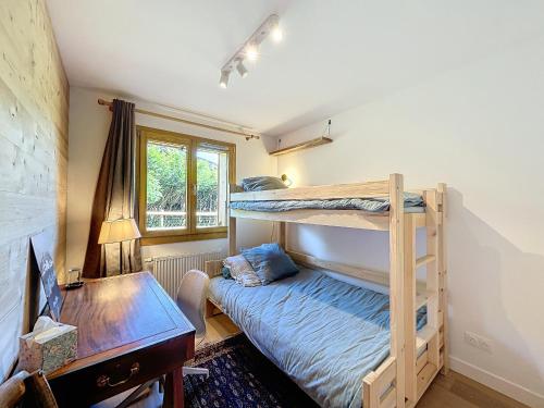 une chambre avec deux lits superposés et un bureau dans l'établissement Appartement neuf 3 chambres à Combloux, vue Mont Blanc, jardin, parking, wifi - FR-1-560-143, à Combloux
