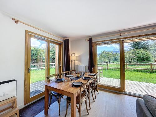 une salle à manger avec une longue table avec des chaises dans l'établissement Appartement neuf 3 chambres à Combloux, vue Mont Blanc, jardin, parking, wifi - FR-1-560-143, à Combloux