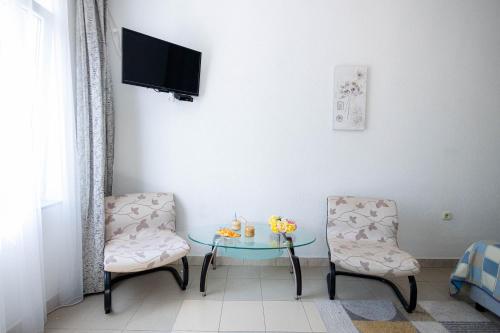a room with two chairs and a table and a tv at Studio apartment Kasalo in Kaštela