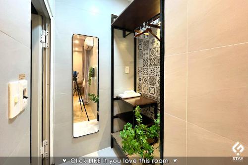 La salle de bains est pourvue d'un miroir et d'une plante. dans l'établissement FSTAY GARDEN CORNER - Cozy and Peaceful Homestay in Da Nang, à Đà Nẵng