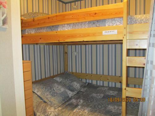 ein Etagenbett in einem Zimmer mit einem Etagenbett aus Holz in der Unterkunft Appartement à GOURETTE, résidence EURONEIGE, avec balcon, vue idéale sur la montagne - 6 personnes in Eaux-Bonnes