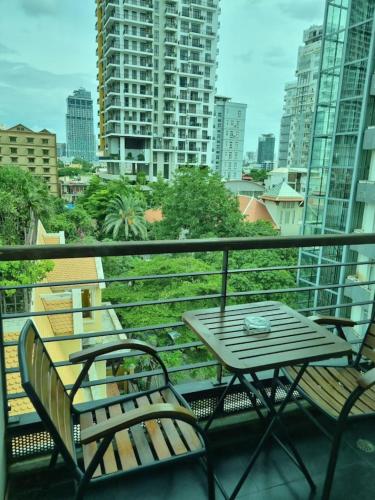 a table and chairs on a balcony with a view of a city at Monsoon Bassac Hotel in Phnom Penh