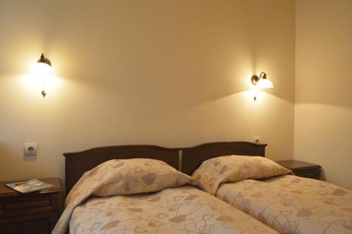 a bedroom with two beds and two lights on the wall at Apartments & Studios Mountain Romance in Bansko