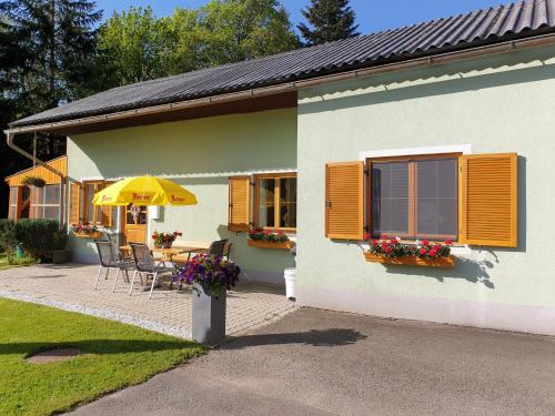 a house with a table and chairs and an umbrella at ferienhausfindling St.Lambrecht in Sankt Lambrecht