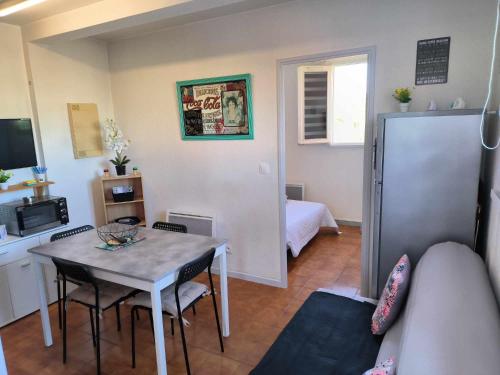 un salon avec une table et un réfrigérateur dans l'établissement chantrelle, à Saint-Cyprien