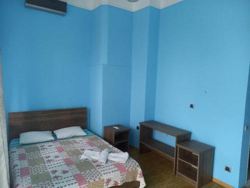 a bedroom with a bed and a blue wall at Ilia's Sweet Home in Batumi