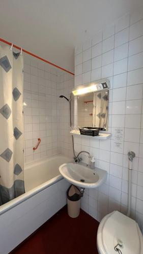 a bathroom with a sink and a toilet and a tub at Aranypart Hostel in Siófok
