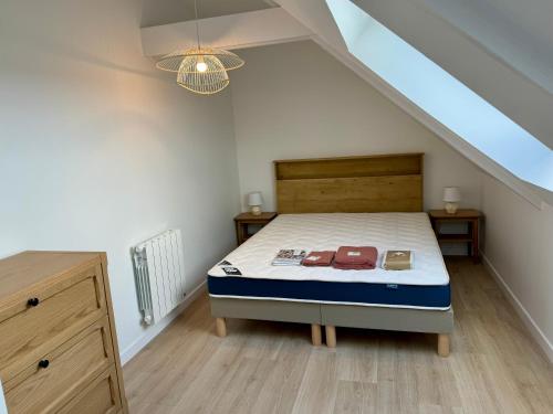 - une chambre mansardée avec un lit et 2 tables de nuit dans l'établissement Bord de mer en Bretagne Sud, à Névez