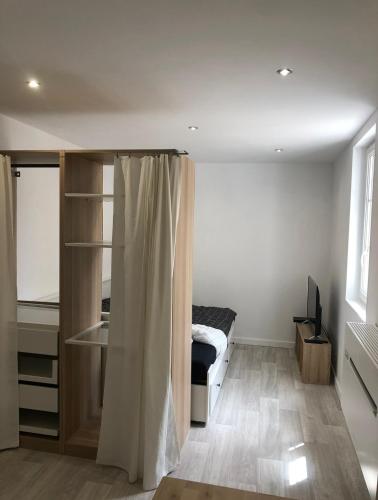 une petite chambre avec un lit et un bureau dans l'établissement Intra-Muros Studio Proche Teinturiers, à Avignon