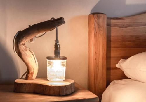 a lamp on a night stand next to a bed at Chalet Ruan Montriond - Mountain Voyages in Montriond