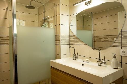 une salle de bain avec un lavabo et un miroir dans l'établissement La Villa Jade, à La Teste-de-Buch