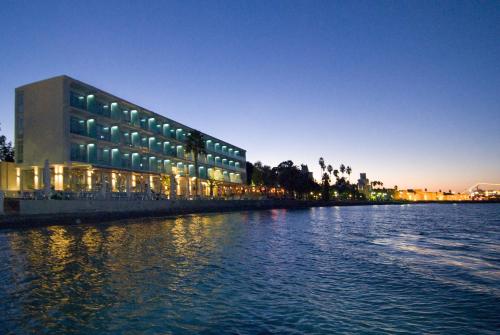 a building on the side of a river at night at Kos Aktis Art Hotel in Kos Town