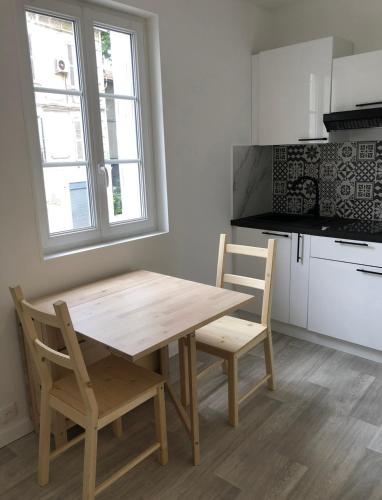 une cuisine avec une table en bois et deux chaises dans l'établissement Intra-Muros Studio Proche Teinturiers, à Avignon