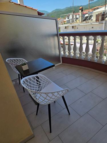 uma varanda com uma mesa e cadeiras. em petros house em Sarti