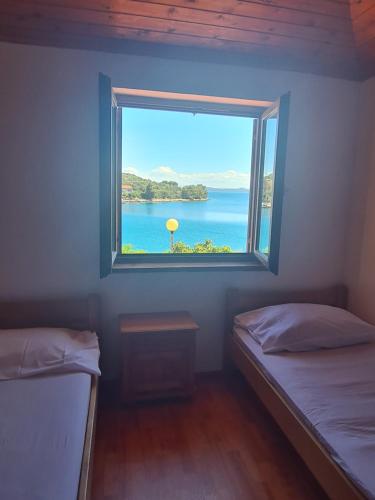 a window in a room with a view of the ocean at Apartment Zaglav 2 - first sea row in Zaglav