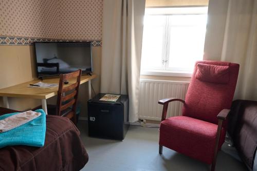 a room with a desk and a chair and a television at Liekorannan Majatalo- kodinomaista majoitusta rautatieasemaa vastapäätä in Sastamala