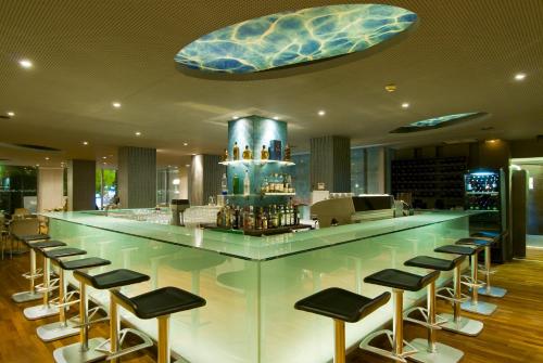 a bar with a bunch of stools in a restaurant at Kos Aktis Art Hotel in Kos Town