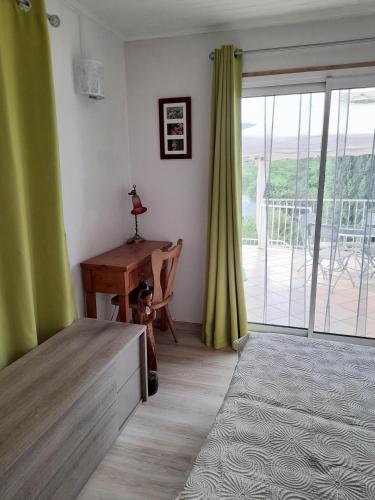 - un salon avec un bureau et une porte coulissante en verre dans l'établissement Gîte 2 pers dans havre de paix cévenol, à Laroque