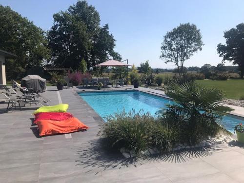 une grande piscine avec une couverture rouge à côté dans l'établissement Villa avec piscine, à Janville