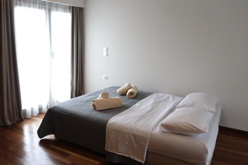 a bedroom with a bed with two teddy bears on it at The Stonehouse at the Harbor in Pythagoreio