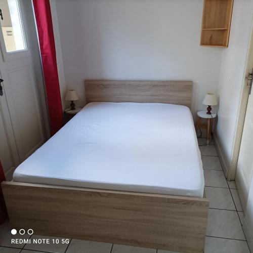 Ce lit se trouve dans un dortoir doté d'un matelas blanc. dans l'établissement Appartement Dumas, à Bayeux