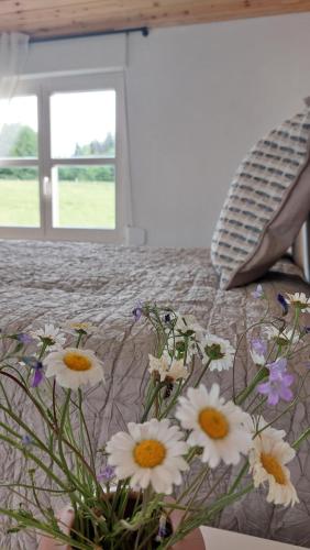 a vase of flowers sitting on a bed at Tiny Moldovibe in Filioara