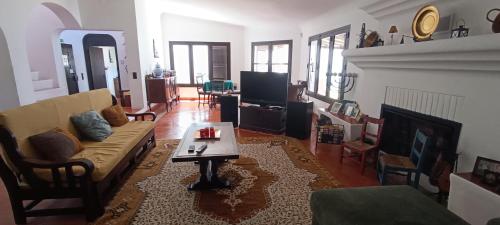 a living room with a couch and a coffee table at Casa das Hortências By Alojamentos Vitinho - Vila Nova MIlfontes in Vila Nova de Milfontes
