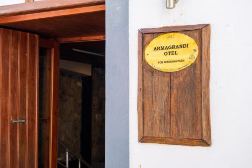 a sign on the side of a building next to a door at Armagrandi Hotel Bozcaada-Special Category in Bozcaada